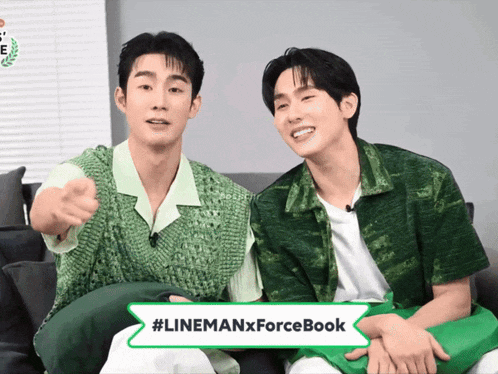 two men are sitting next to each other with a #linemanxforcebook sign in front of them