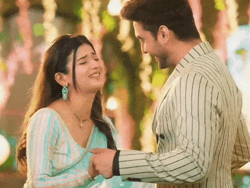 a man and a woman are looking at each other and the woman is smiling .