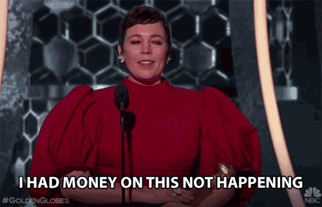a woman in a red dress is holding a golden globes trophy and says i had money on this not happening