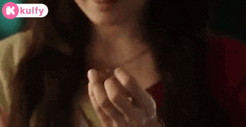 a woman with a nose ring is eating something with her hand .