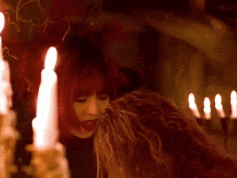 a woman with red hair holds another woman 's hand
