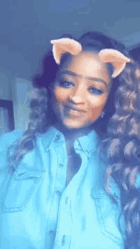a woman wearing a blue shirt and a cat ear filter