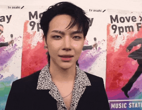 a man stands in front of a poster that says move 9 pm