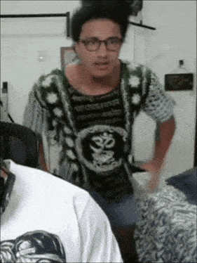 a man wearing glasses and a shirt that says ' ॐ ' on it