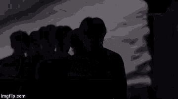 a group of people are standing in a row in front of a screen .