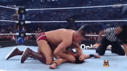 two men are wrestling in a wrestling ring with a sign that says on