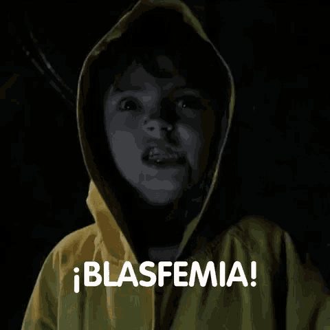a young boy wearing a yellow raincoat with a hood is making a funny face .
