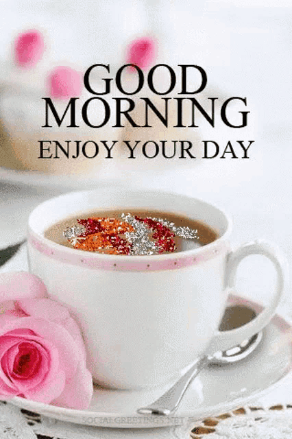a cup of coffee and a pink rose on a saucer with the words `` good morning enjoy your day '' written on it .