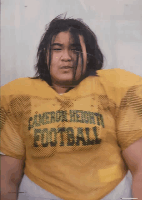 a man wearing a yellow candor heights football shirt