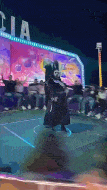 a man in a mask is dancing in front of a sign that says cola
