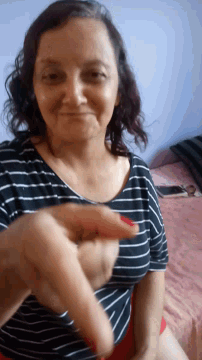 a woman in a black and white striped shirt with red nails