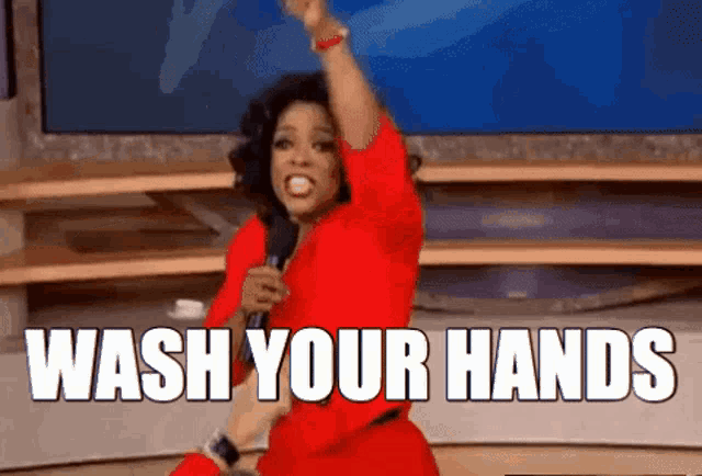 a woman in a red dress is singing into a microphone and says wash your hands