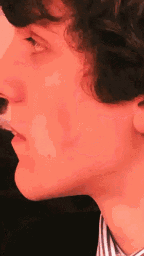 a close up of a man 's face with a red background