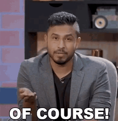 a man in a suit is sitting in a chair and making a funny face while saying `` of course ! ''