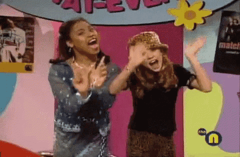 two girls are dancing together in front of a sign that says match
