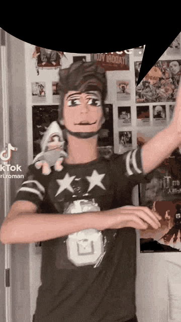 a man wearing a green shirt with stars on it is holding a doll ..
