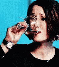 a woman drinking a glass of wine with a watch on her wrist