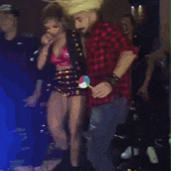 a man in a plaid shirt is dancing with a woman in a pink top