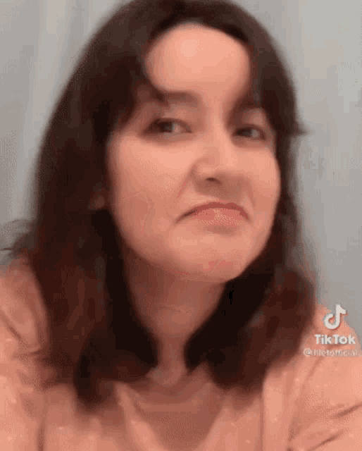 a close up of a woman 's face with a tik tok logo on the bottom .
