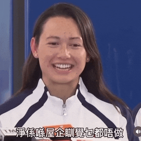 a woman in a white and blue jacket is smiling with chinese writing behind her