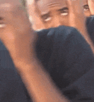 a blurry picture of a man making a funny face with his hands in the air .