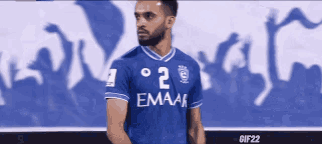 a soccer player wearing a blue jersey that says emaar