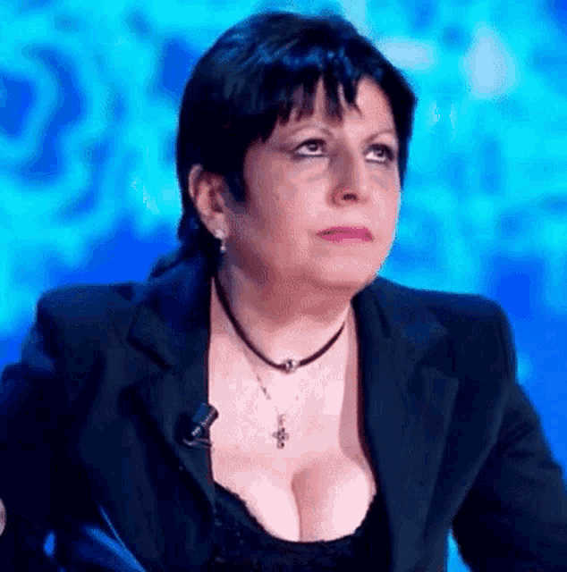 a woman with a very large breast is sitting in front of a microphone on a television show .