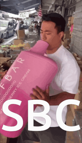 a man is holding a pink container that says sbc on it