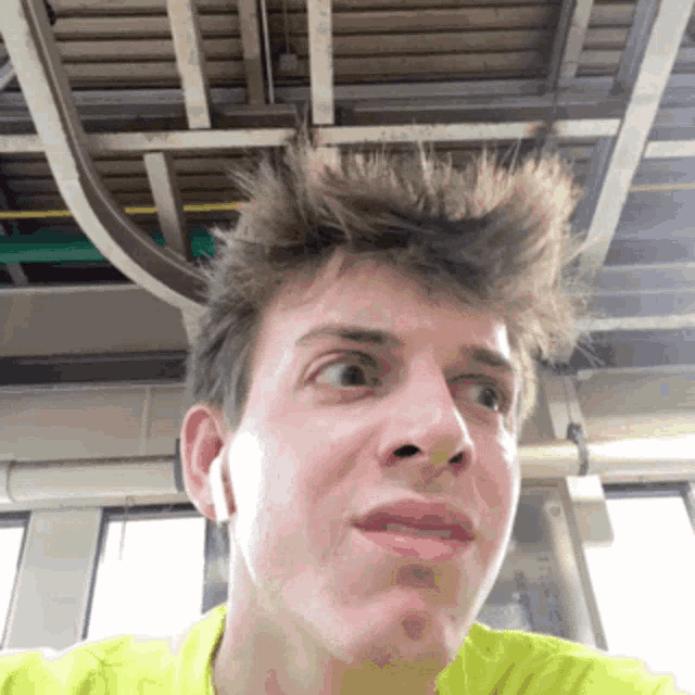 a man wearing a yellow shirt is making a face