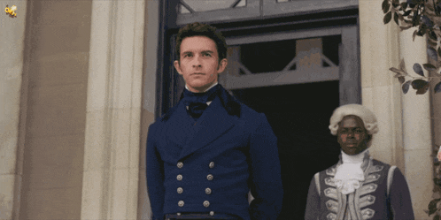 a man in a blue coat is standing next to a man in a white wig