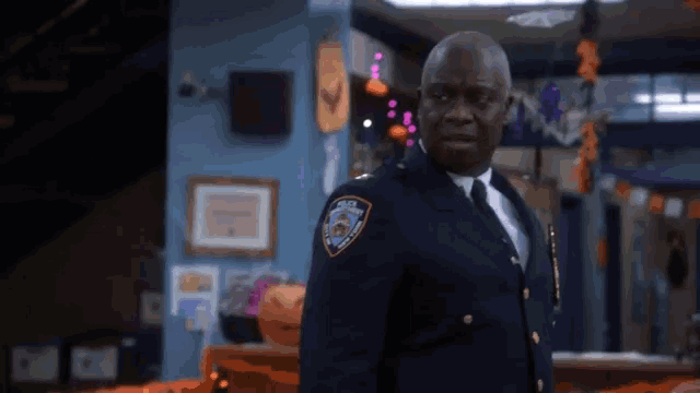a police officer is standing in a room decorated for halloween .