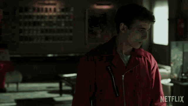 a man in a red jacket is sitting in front of a netflix sign