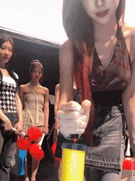 a woman is holding a yellow item that says ' balloons ' on it