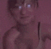 a blurry picture of a woman with glasses giving a peace sign