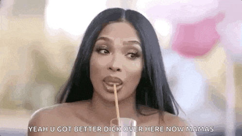 a woman is drinking a drink with a straw in her mouth .