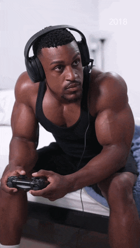 a man wearing headphones is playing a video game with the year 2018 in the corner