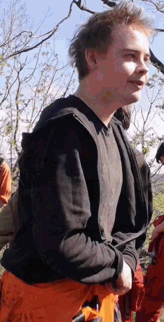 a man wearing a black shirt and orange pants