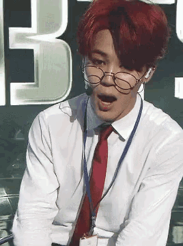 a man with red hair is wearing glasses and a name tag