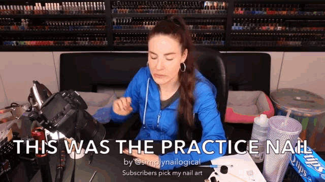 a woman in a blue jacket sits at a desk with the words " this was the practice nail "
