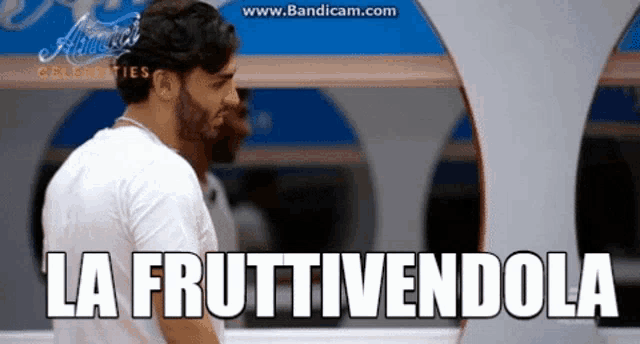 a man is standing in front of a sign that says la fruittivendola