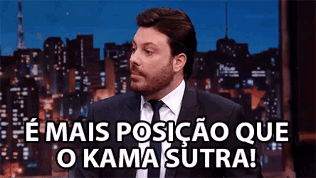 a man in a suit and tie is sitting in front of a city skyline and says " mais posicao que o kama sutra "