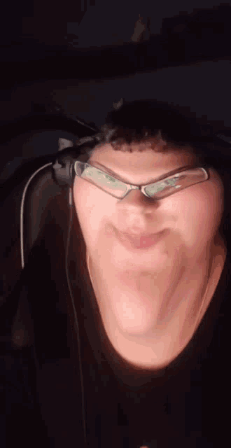 a man wearing headphones and glasses is making a funny face
