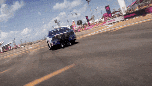 a chevrolet race car is driving down a track with a crowd watching