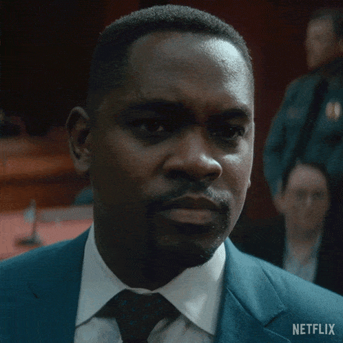 a man in a suit and tie with a netflix logo on the bottom right