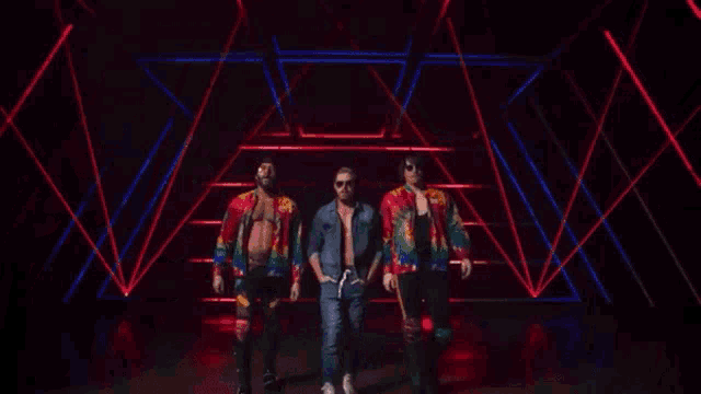 a group of men standing in front of a red light