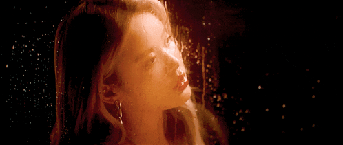 a close up of a woman 's face with water drops on her face