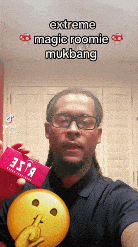 a man with glasses holds a box that says extreme magic roomie mukbang