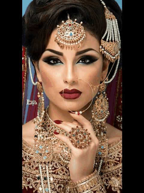 a woman wearing a lot of gold jewelry has the word laya on the bottom