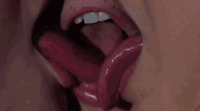 a close up of a woman 's mouth with her tongue sticking out .