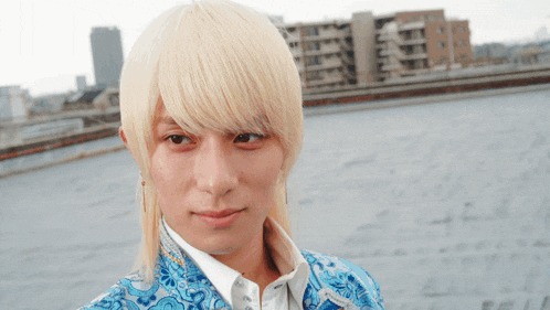 a man with blonde hair is wearing a blue and white jacket